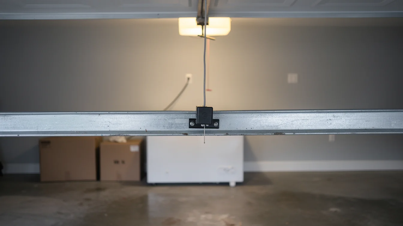 The garage door opener rail has a safety release cord and a light.